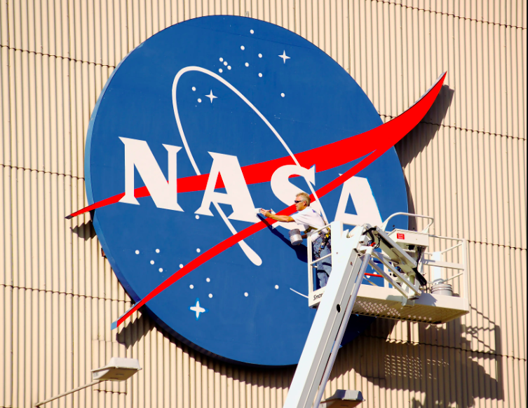 USA A painter applies a fresh coat of paint to the NASA “meatball” logo on the north façade of Glenn Research Center’s Flight Research Building, or hangar, in 2006. Credit: NASA/Marvin Smith